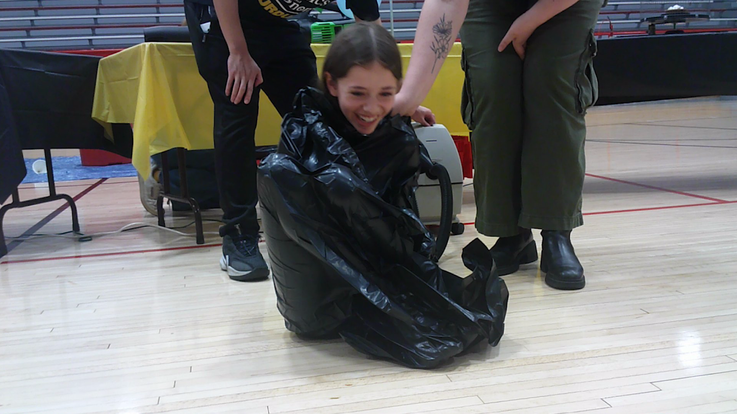 A girl in a vacuumed trash bag